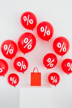 Red balloons with percentage symbols and a shopping bag on white background.